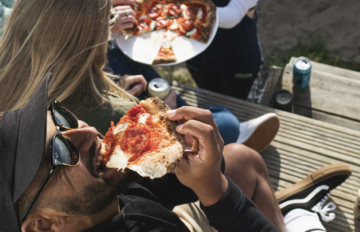 Man eating pizza outside