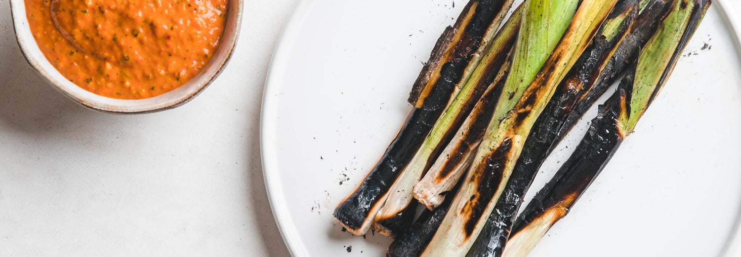 Charred Baby Leeks with Romesco Sauce - Gozney . Roccbox recipe poster image