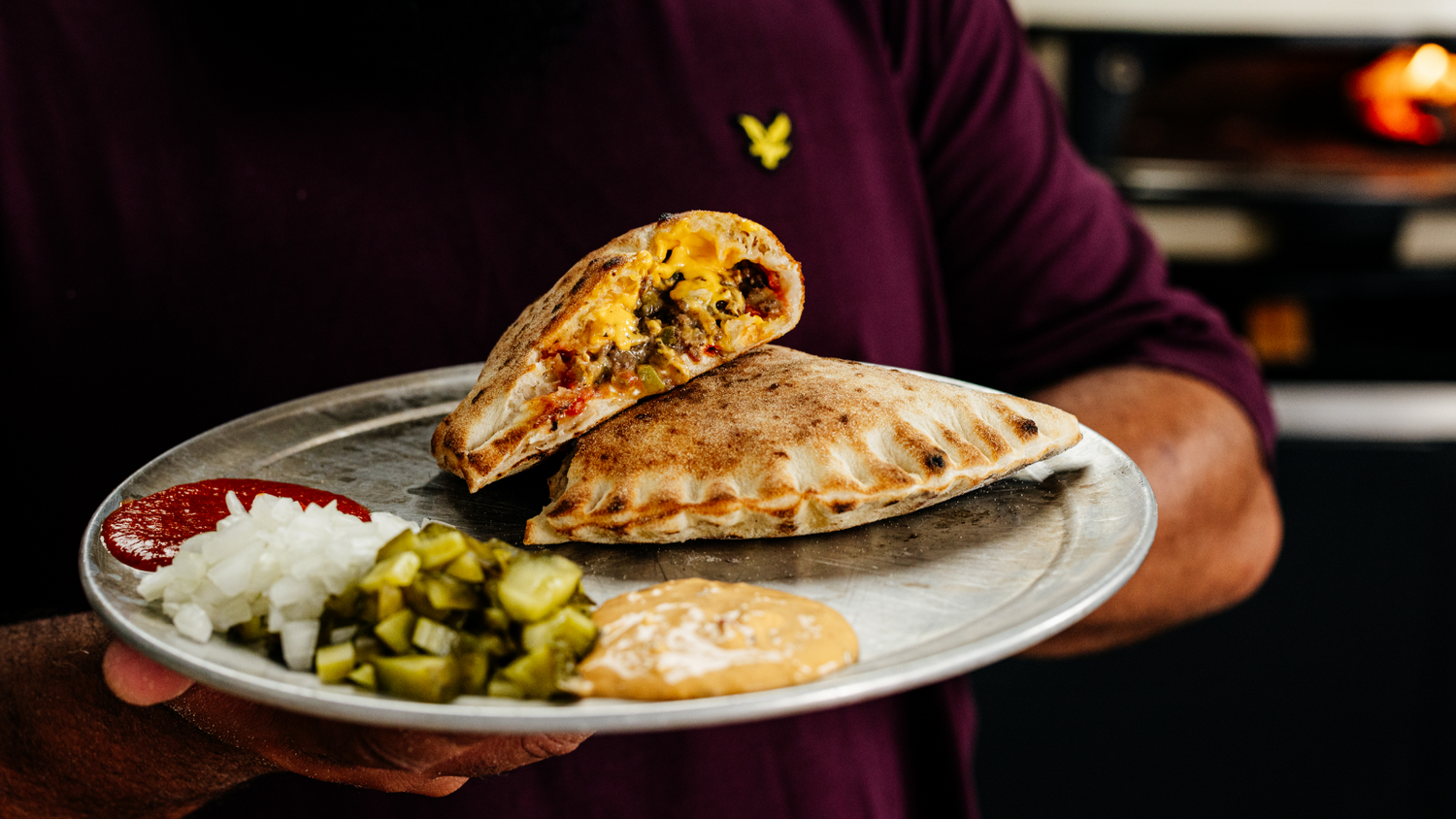 Chopped Cheese Calzone stacked on a plate.