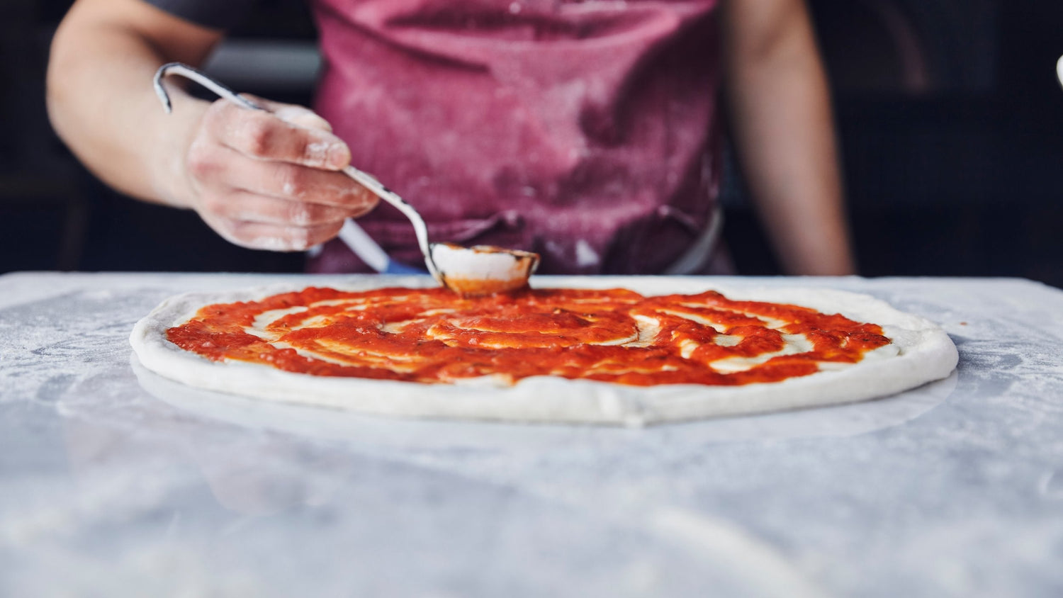 Spreading Marinara Sauce on pizza dough