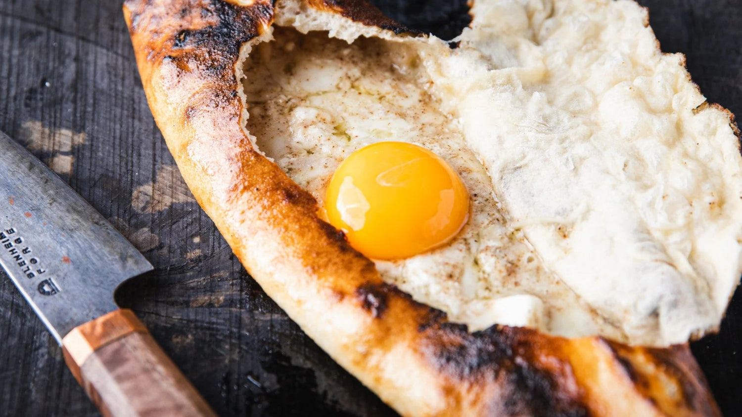 Cheese pide next to knife recipe poster image